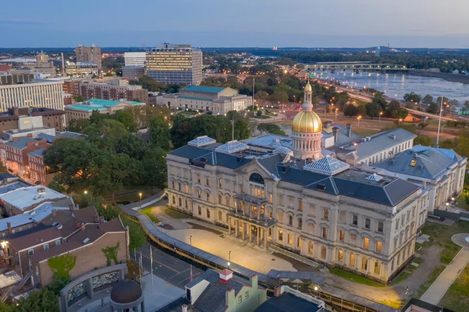 Aerial view of gold-covered New Jersey state capitol dome in Trenton, New Jersey at dusk.